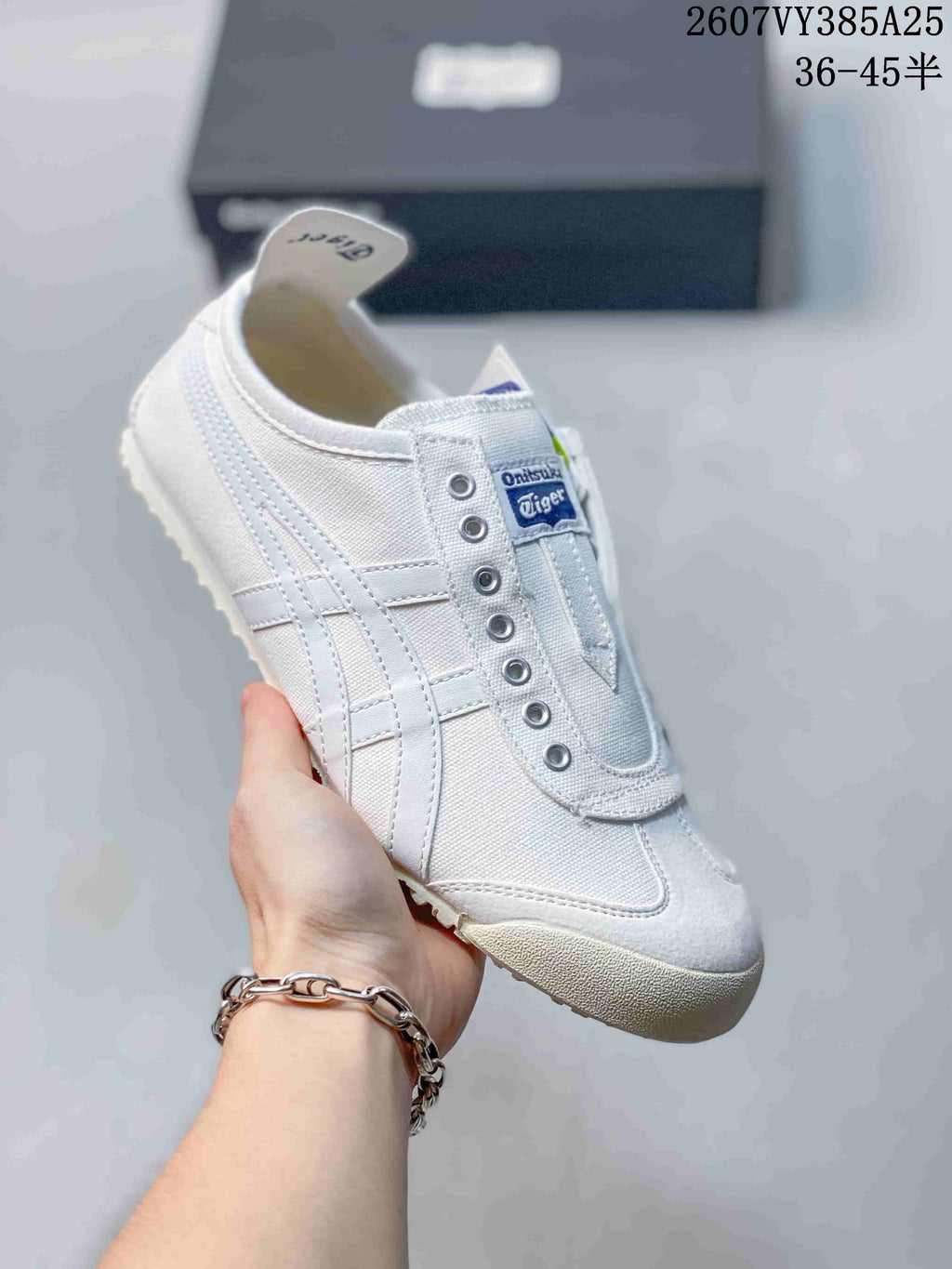 White monochrome slip-on sneaker with subtle contrasting details and a light outsole.