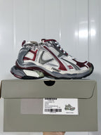 Side view of the Puma Runner sneaker displayed on its product box, showing the style label and layered upper.