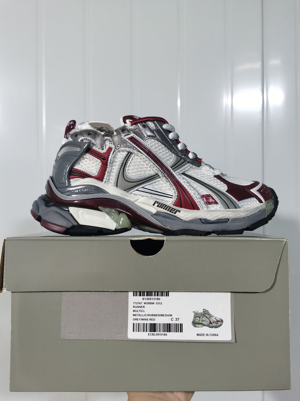 Side view of the Puma Runner sneaker displayed on its product box, showing the style label and layered upper.