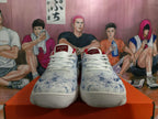 Front view of Nike shoes with white laces, red tongue labels, and mottled white and blue uppers.