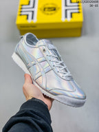 Close view of a silver low-top sneaker showing the lace-up design, side stripes, and patterned outsole.