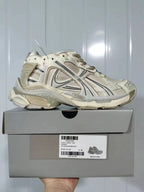 Side view of beige and yellow Reebok 1205 runner sneakers displayed on their box; the label shows model 1205, color Beige Yellow, and size E40.
