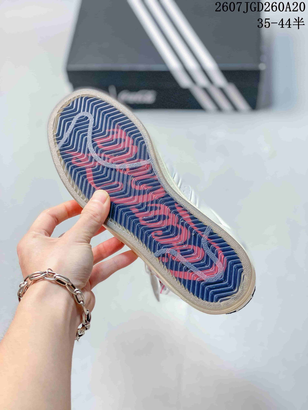 Close view of the sneaker outsole showing a navy and red zigzag pattern.