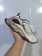 Angled close-up showing the layered upper, contrasting panels, chunky midsole, and dark outsole of the Balenciaga Triple S 2 2290 sneaker.