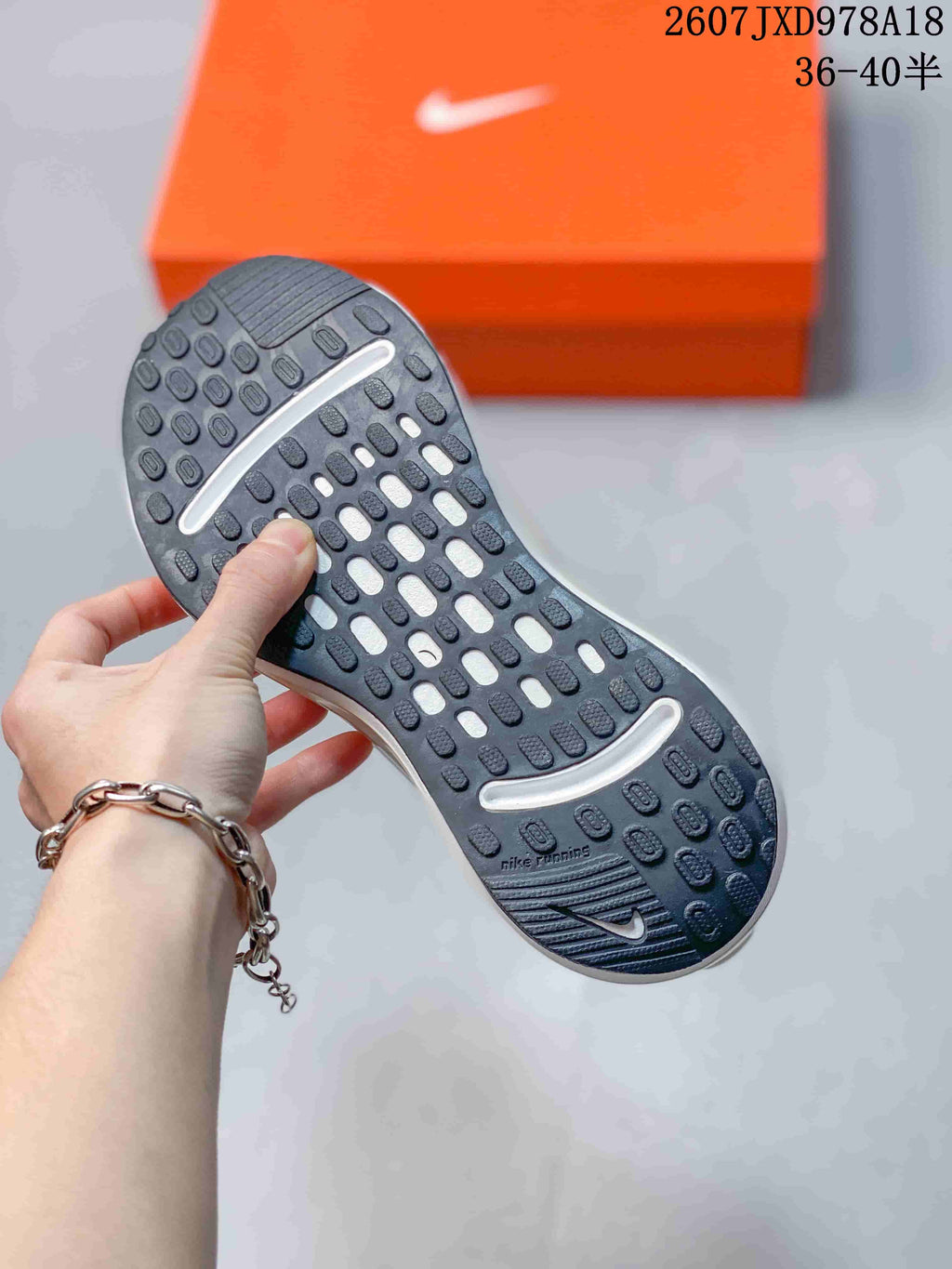 Close-up of the black textured outsole showing segmented traction pods and white cushioning openings.