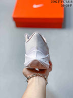 Rear view of the white sneaker showing the padded heel collar and outsole details.