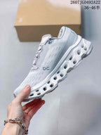 Side profile showing the light gray upper, On branding and open-cutout white sole.