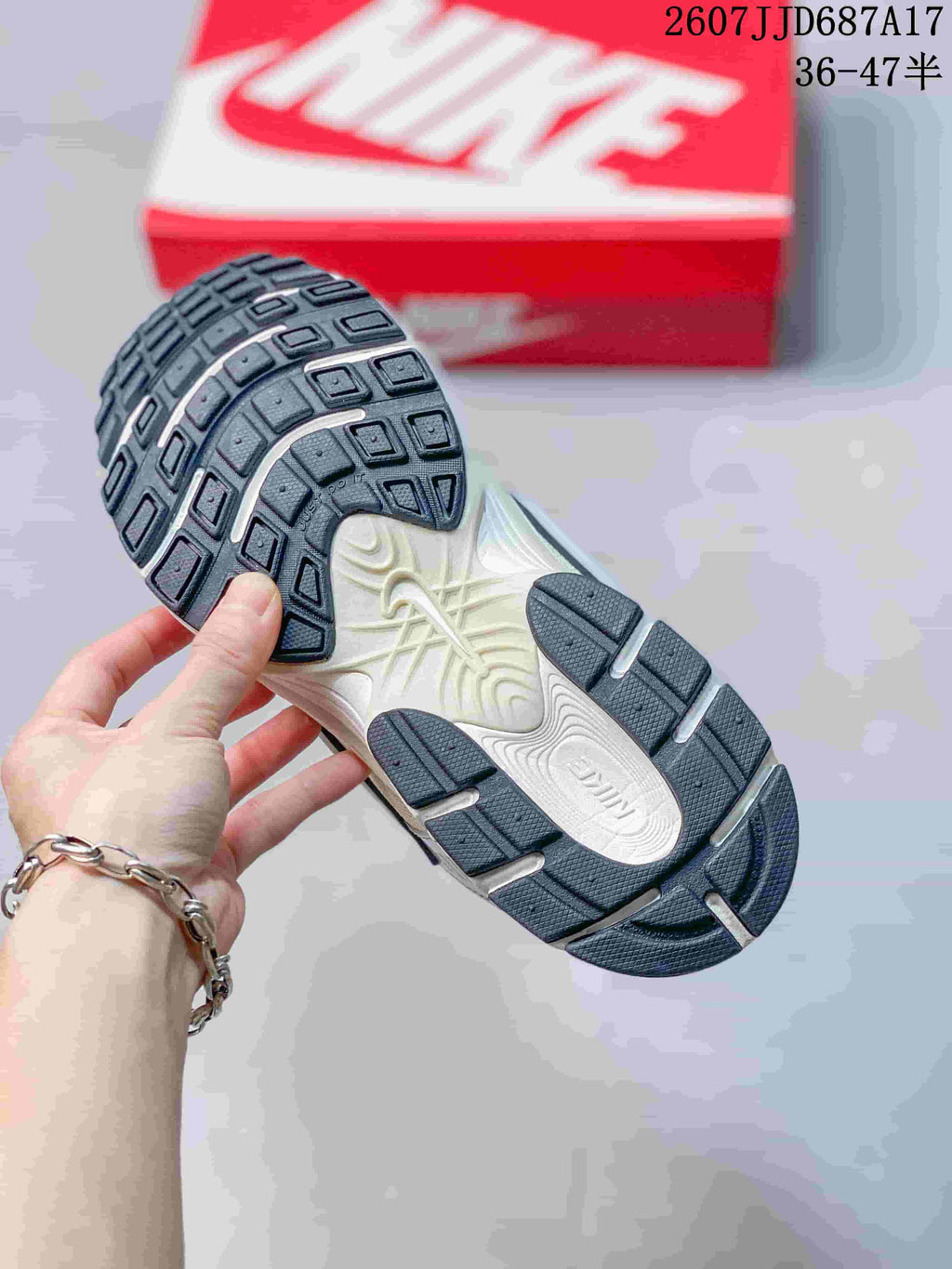 Underside of the sneaker showing a segmented black-and-white rubber outsole with textured tread.