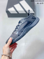 Side view of the dark gray adidas sneaker showing its low-profile shape, mesh-look panels, and layered upper.