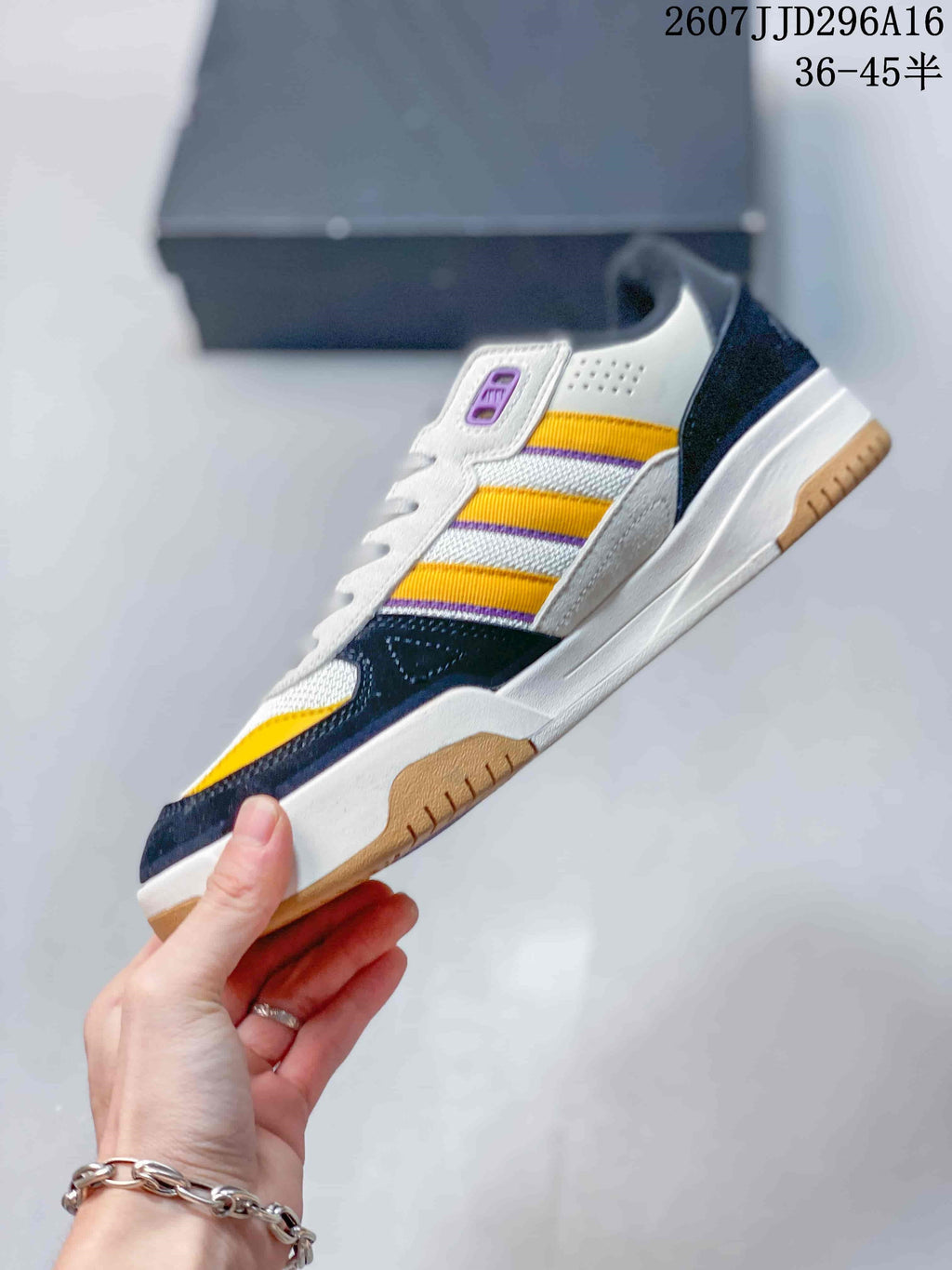 Side profile of the adidas Tekkira Cup sneaker showing the layered upper, yellow side stripes, white midsole and gum outsole.