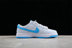 Side profile of the low-top sneaker showing the gray and white upper, bright blue Swoosh, white midsole, and blue outsole.