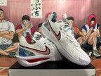 Angled view of a pair of white Nike basketball sneakers displaying the side Swoosh, textured outsole and multicolor camouflage-style detailing.