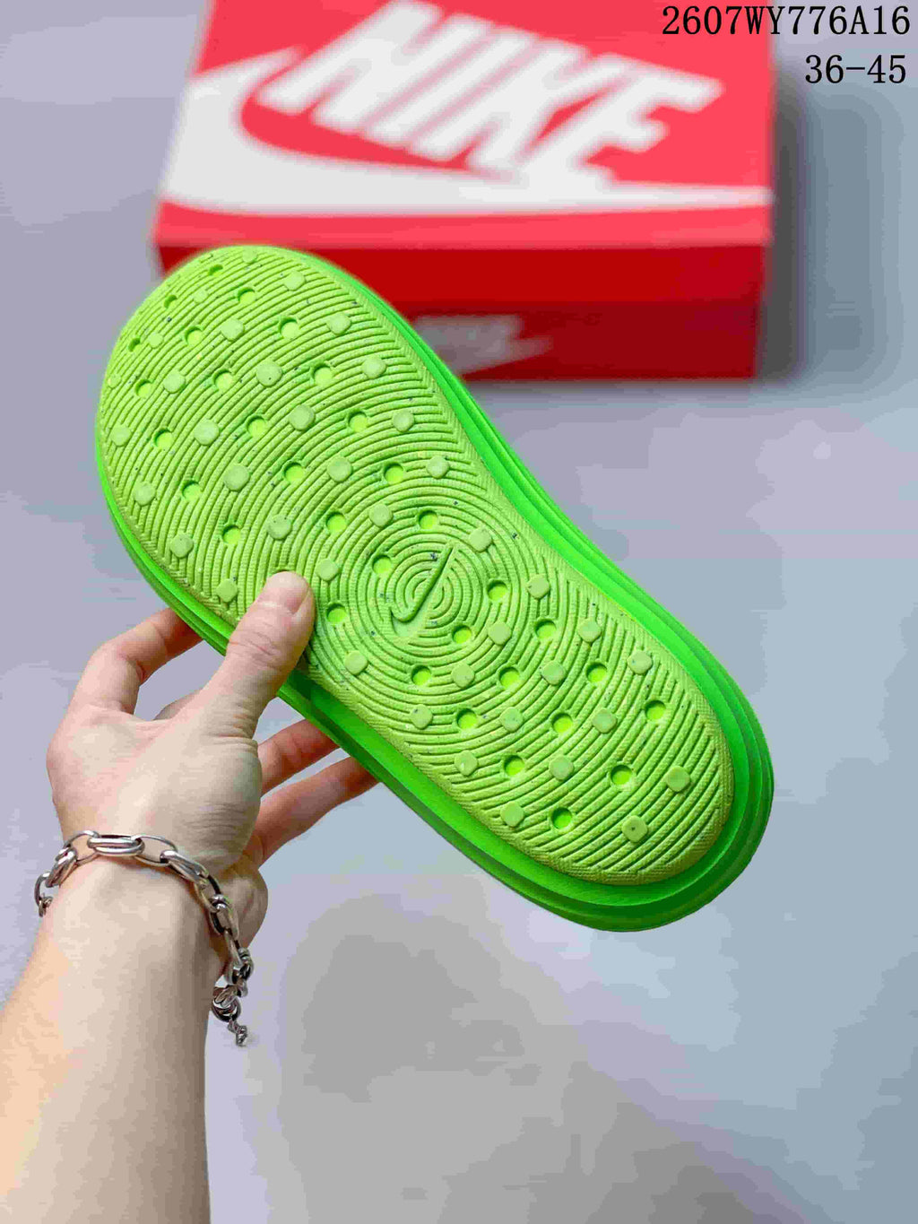 Close view of the textured outsole on a neon green clog, with a circular patterned tread.