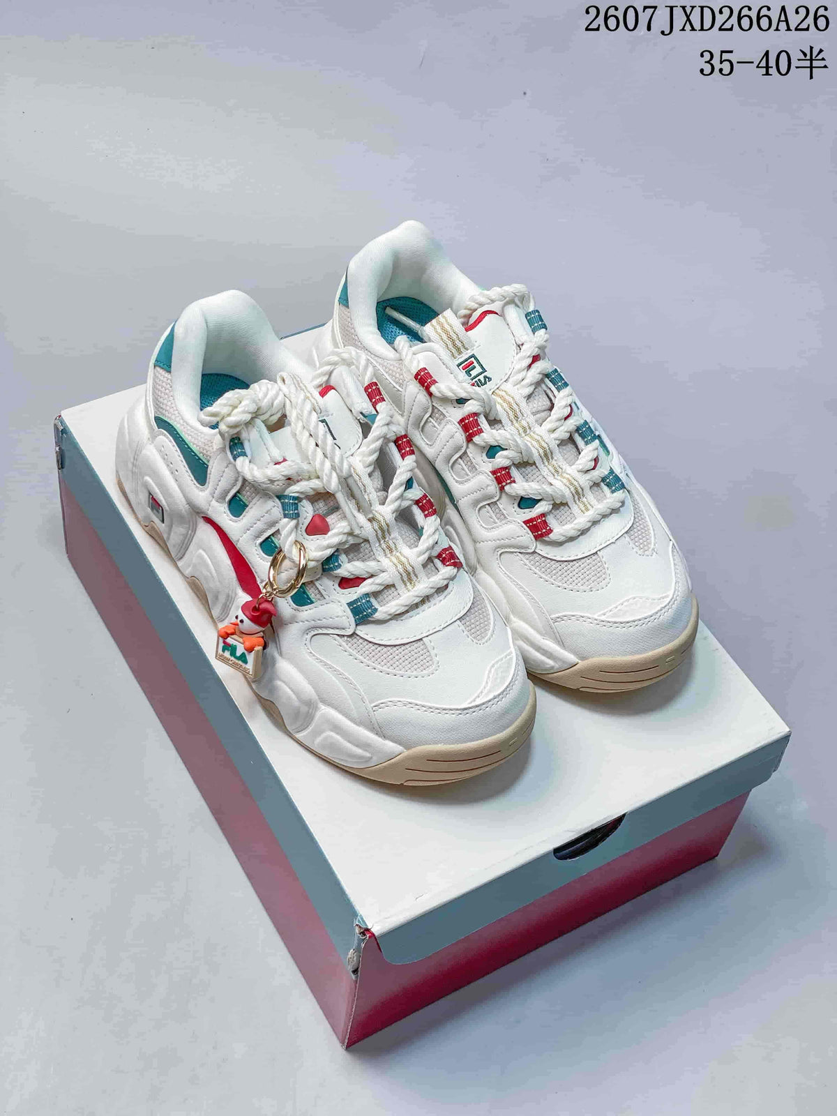 Pair of FILA Croissant sneakers in white and gray with teal and red accents, displayed on a shoebox.