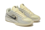 Angled view of a pale yellow and light gray Nike Kobe 5 Protro shoe pair