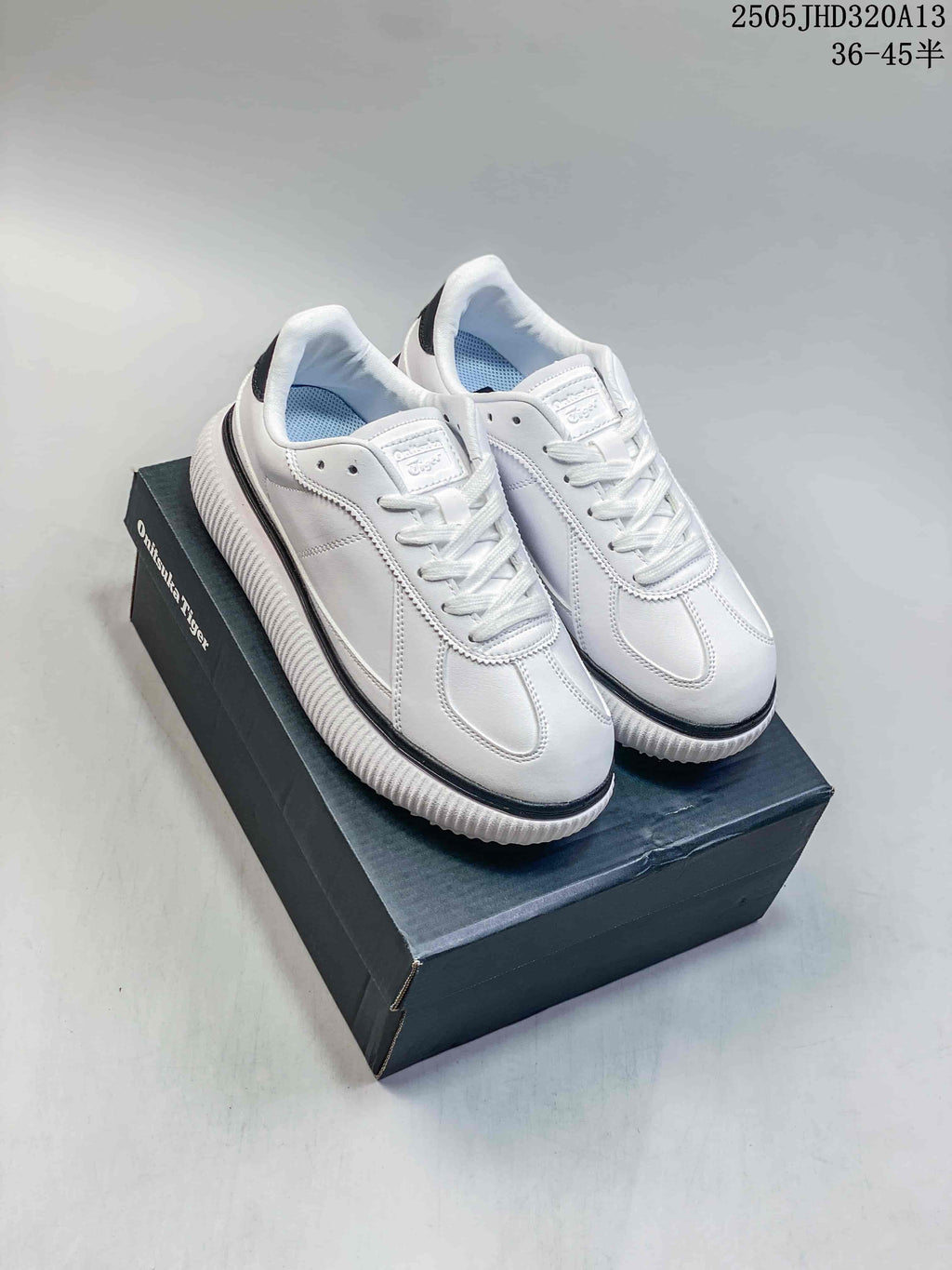 Pair of white Onitsuka Tiger Delecity low-top sneakers with black accents, shown on a box
