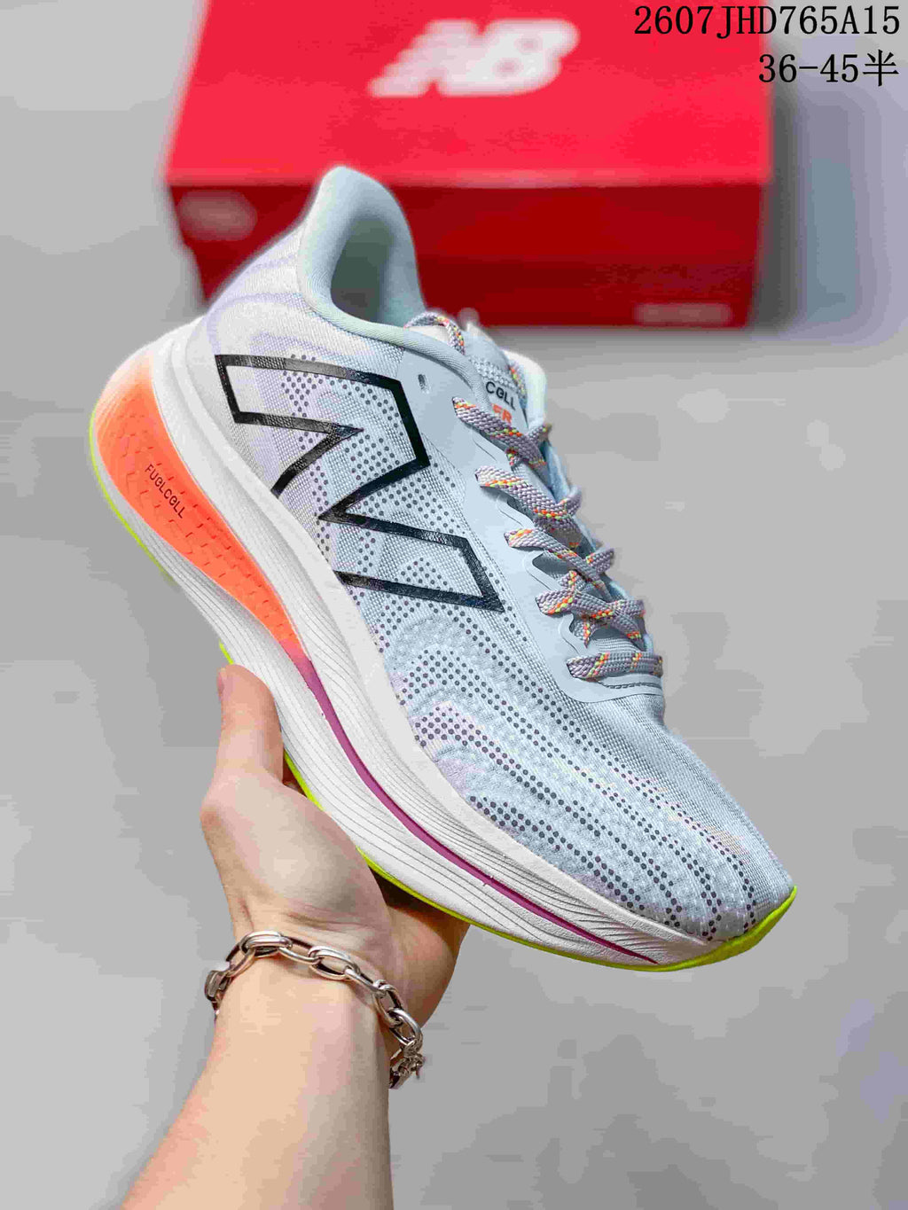 Angled side view of the New Balance RC Elite running shoe showing the logo, FuelCell-marked orange heel section, and lime outsole.