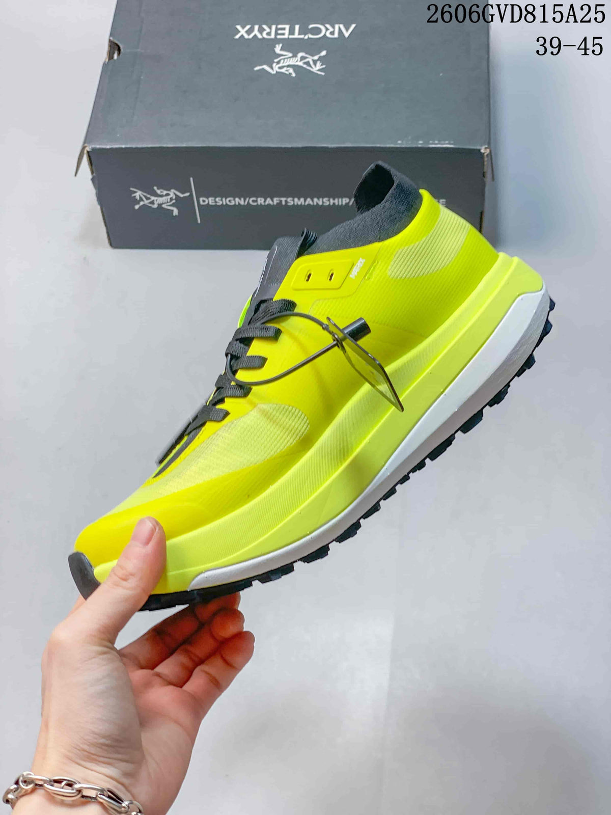 Side view of a neon yellow trail shoe with dark laces and treaded outsole