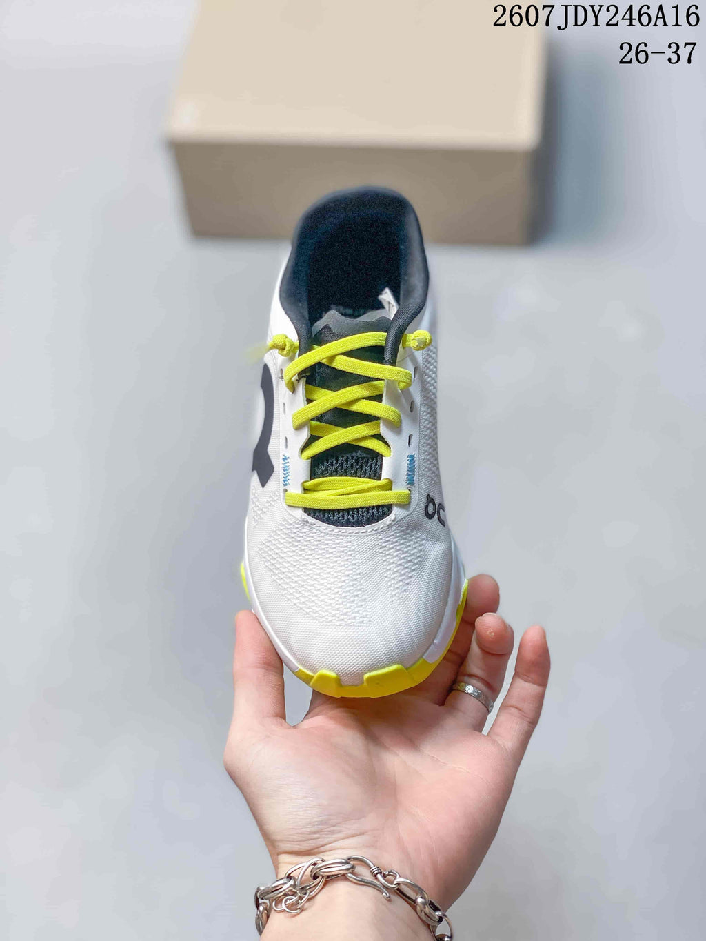 Top view of a white kids' sneaker with lime laces, a dark tongue, and textured upper panels.