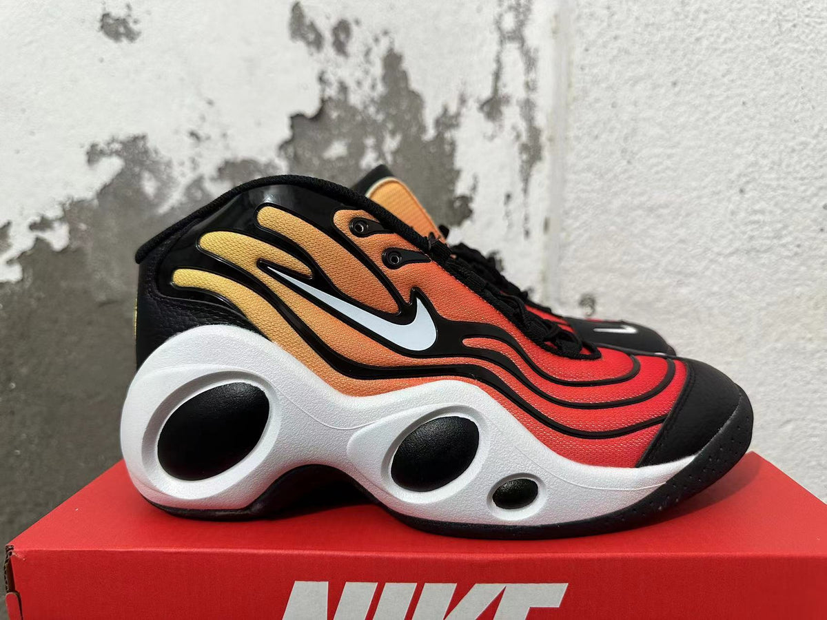 Side view showing the orange gradient upper, white Swoosh, and sculpted sole