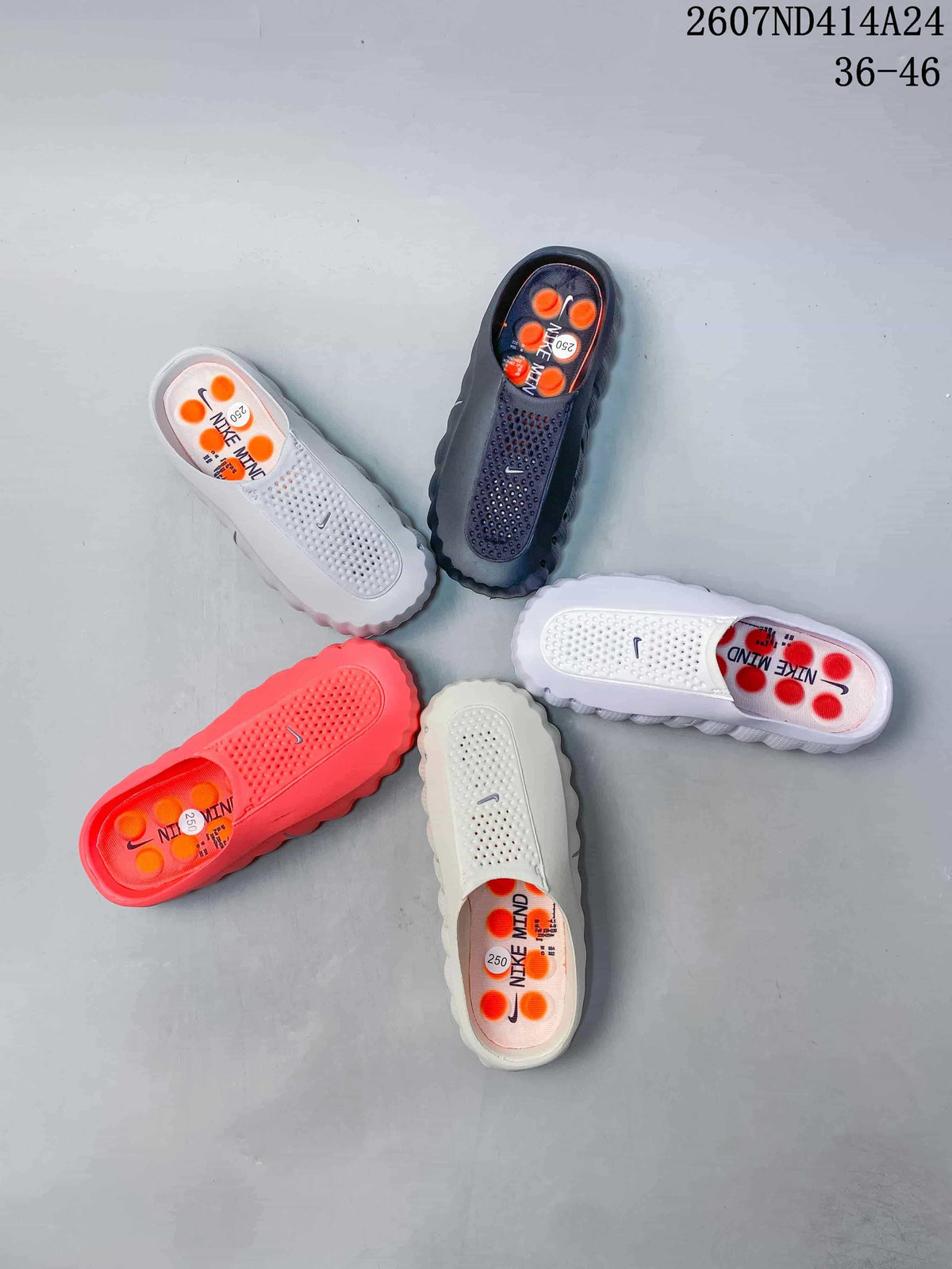 Several Nike Mind 001 slides displayed together in white, black, red, and light neutral colorways.