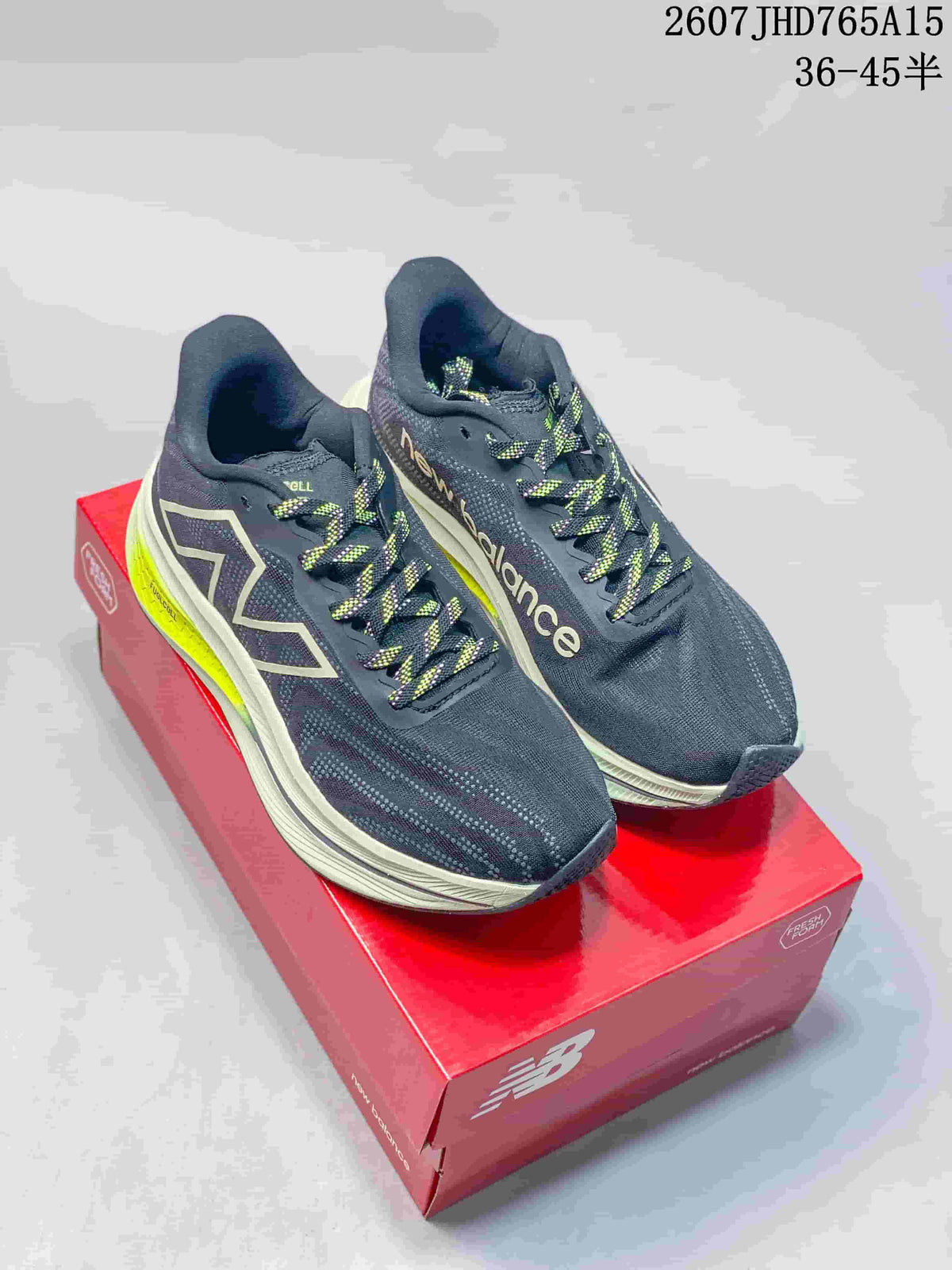 New Balance RC Elite running shoes shown from above on a red shoe box, with dark navy uppers, light midsoles and neon yellow accents.
