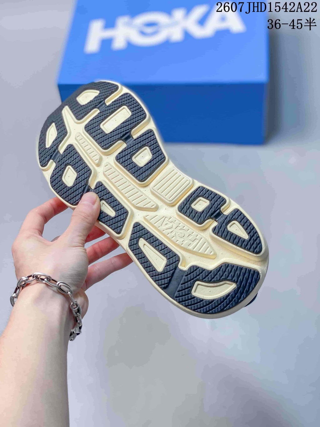 Close-up of the sneaker outsole showing segmented dark and cream traction areas.