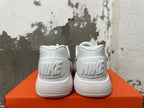 Rear view of white Nike shoes showing NIKE heel branding and ridged soles