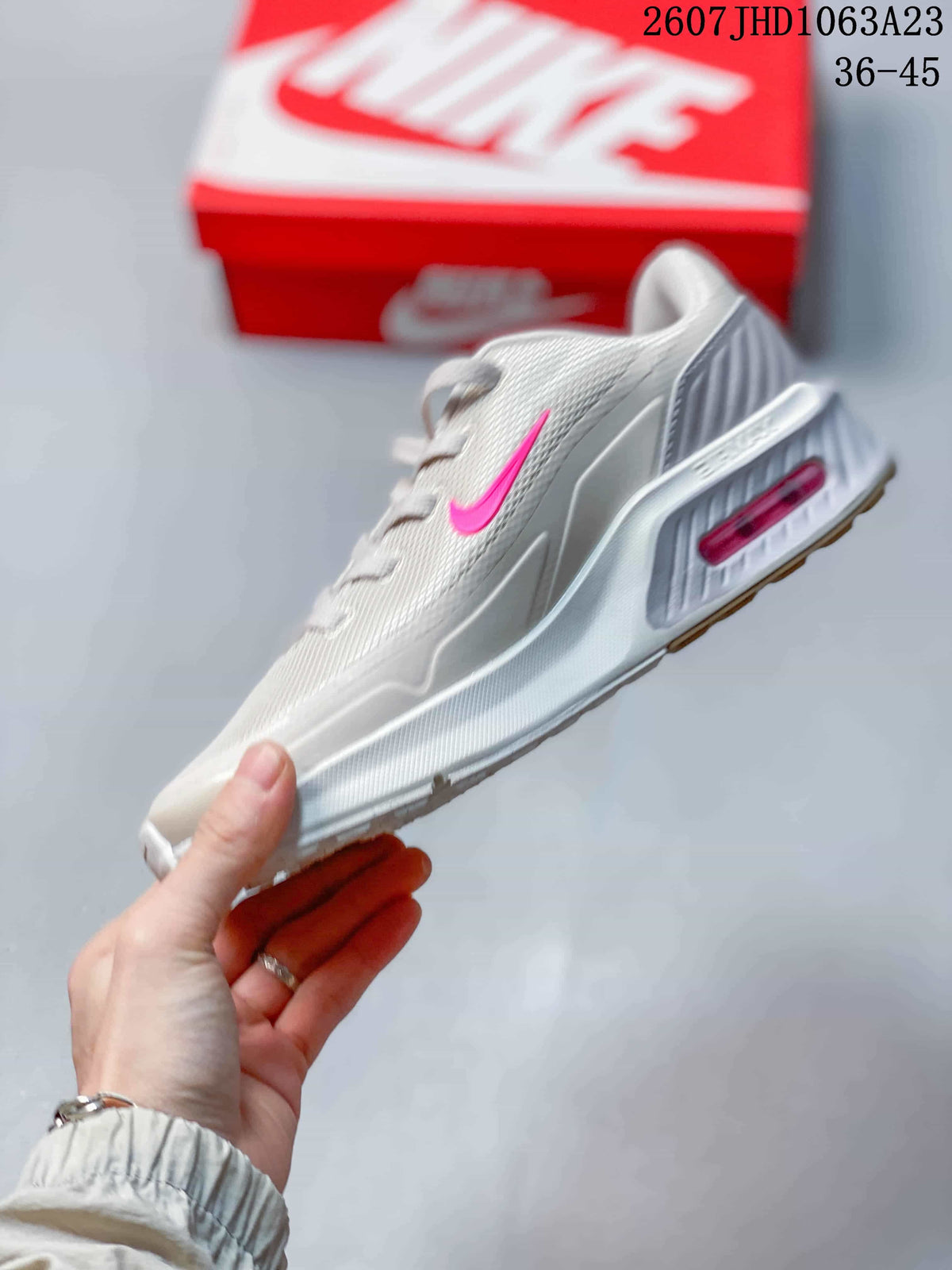 Side profile showing the bright pink Swoosh, sculpted midsole, and heel cushioning unit.