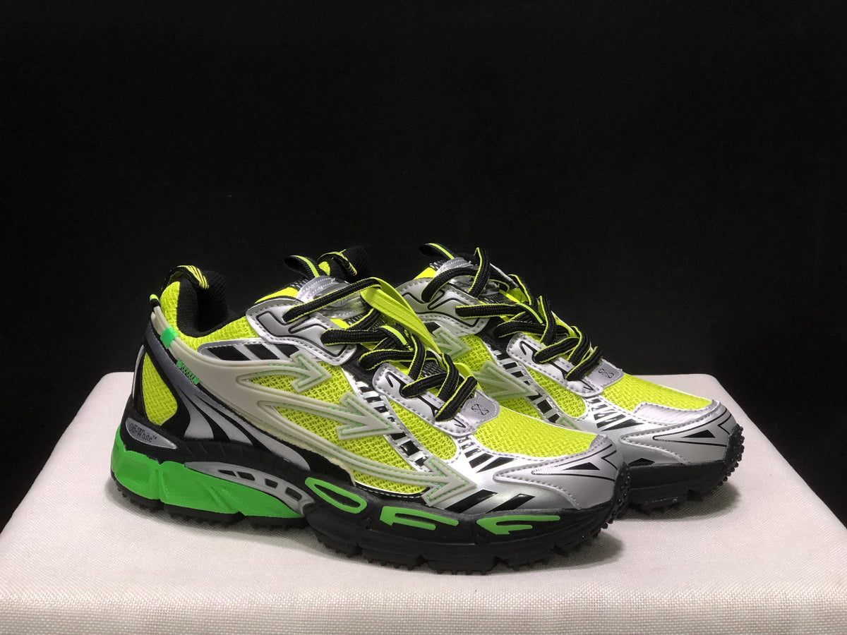 Three-quarter front view of the pair highlighting the silver toe panels, neon uppers, and layered lace system.