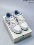 Pair of white and black Nike SB Dunk Low x Stussy sneakers shown on a branded shoe box; image text shows style code 2607JVD1191A21 and size range 36–45.