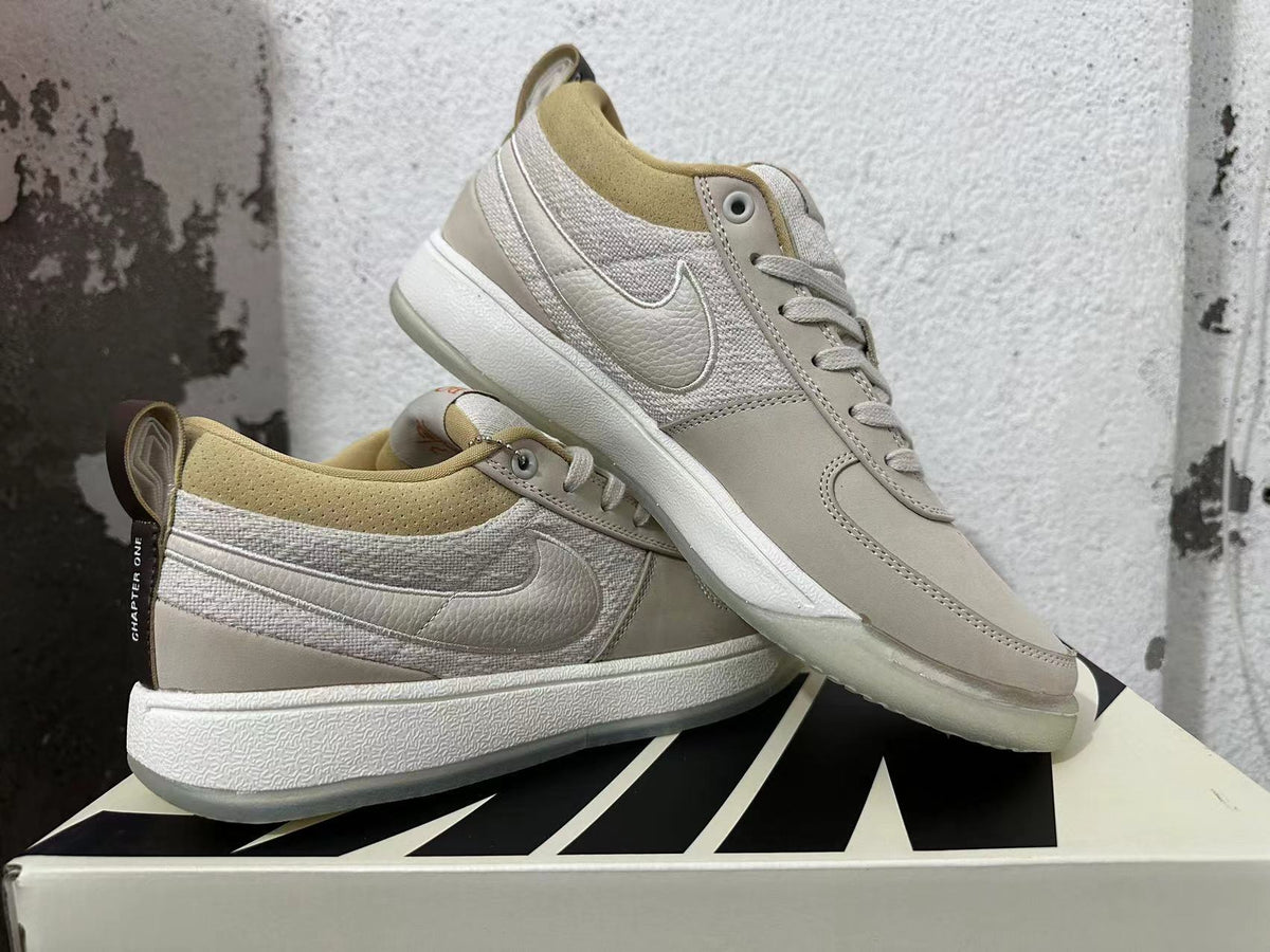 Pair of cream and light grey Nike Book 1 sneakers shown from the side