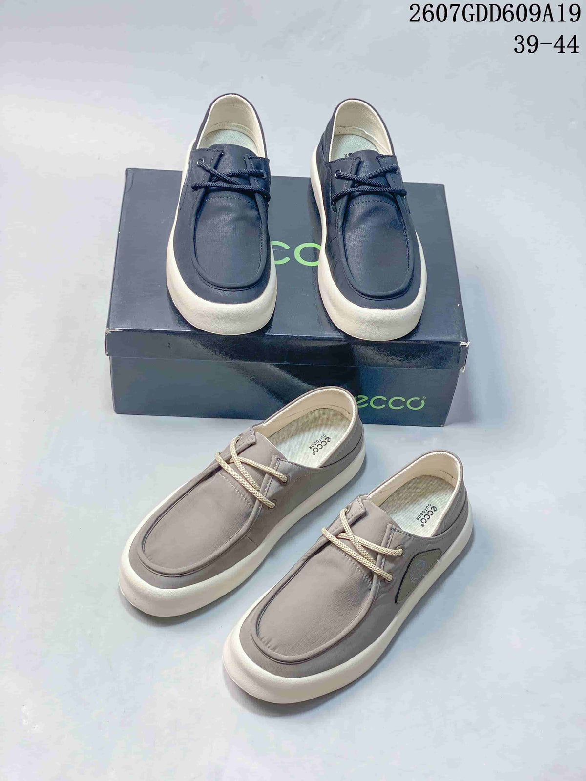 Navy and gray ECCO lace-up sneakers shown from above and beside the branded box; style code 2607GDD609A19 and size range 39–44 are visible.