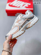 Side view highlighting the layered peach and silver overlays, mesh panels, and sculpted midsole.