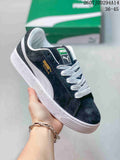 Black and white PUMA Suede XL low-top sneaker with white laces, a white side stripe, textured sole, green tongue label, and gold-toned branding.