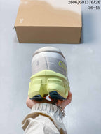 Rear view of the white and lime running shoe showing the padded heel, On branding and layered sole construction.