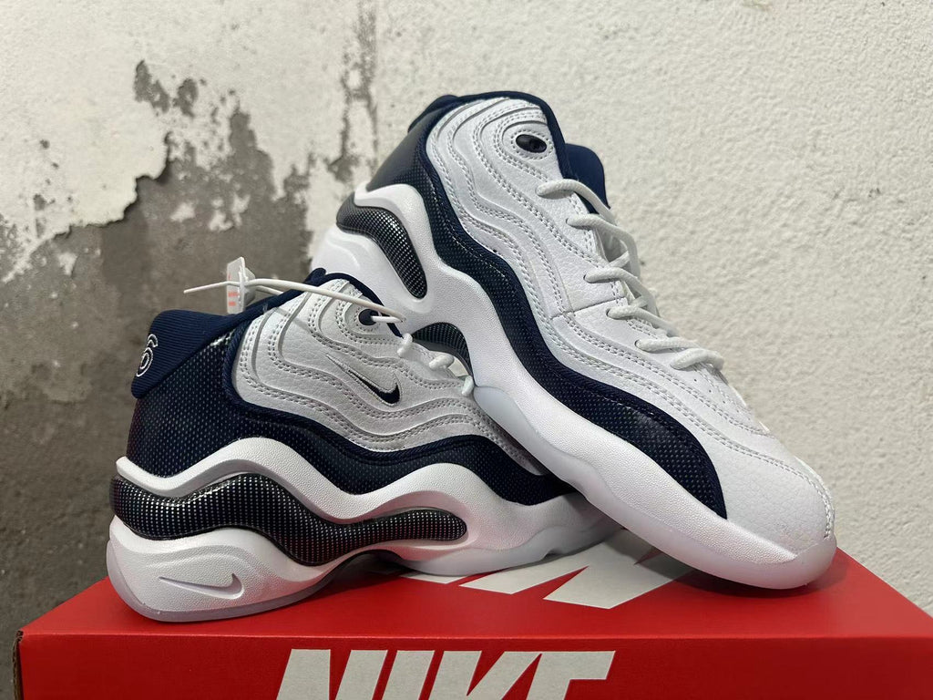 Pair of white and navy Nike sneakers shown from the side.