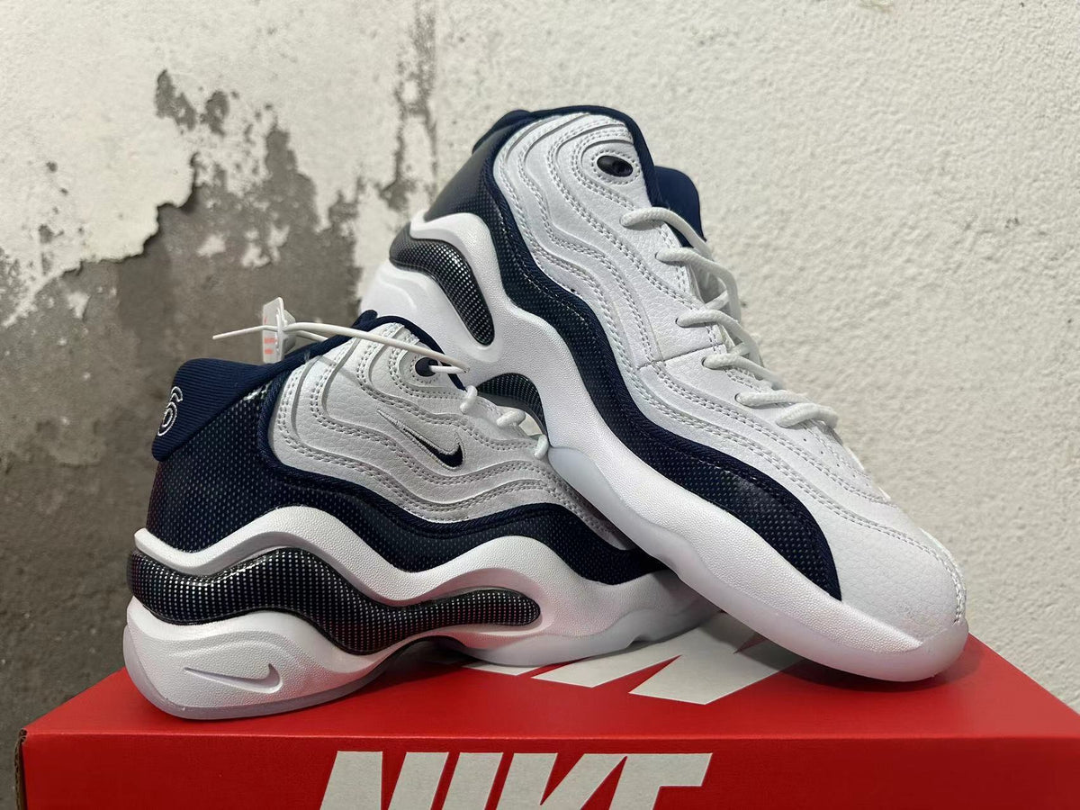 Pair of white and navy Nike sneakers shown from the side.