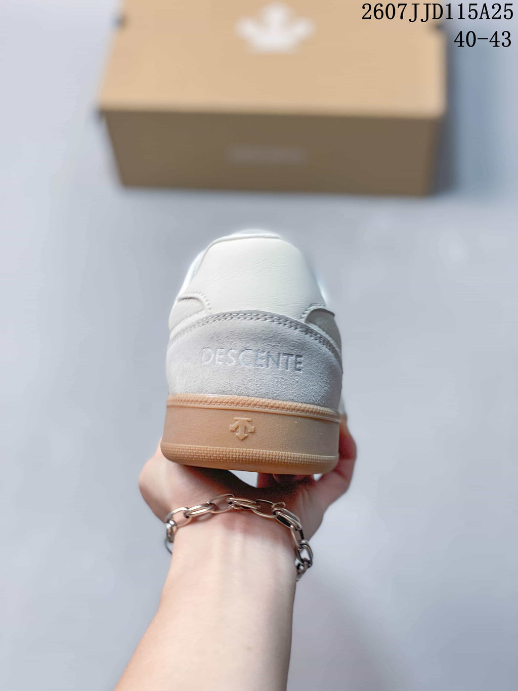 Rear view showing the grey heel panel, DESCENTE branding, and gum-colored heel section.