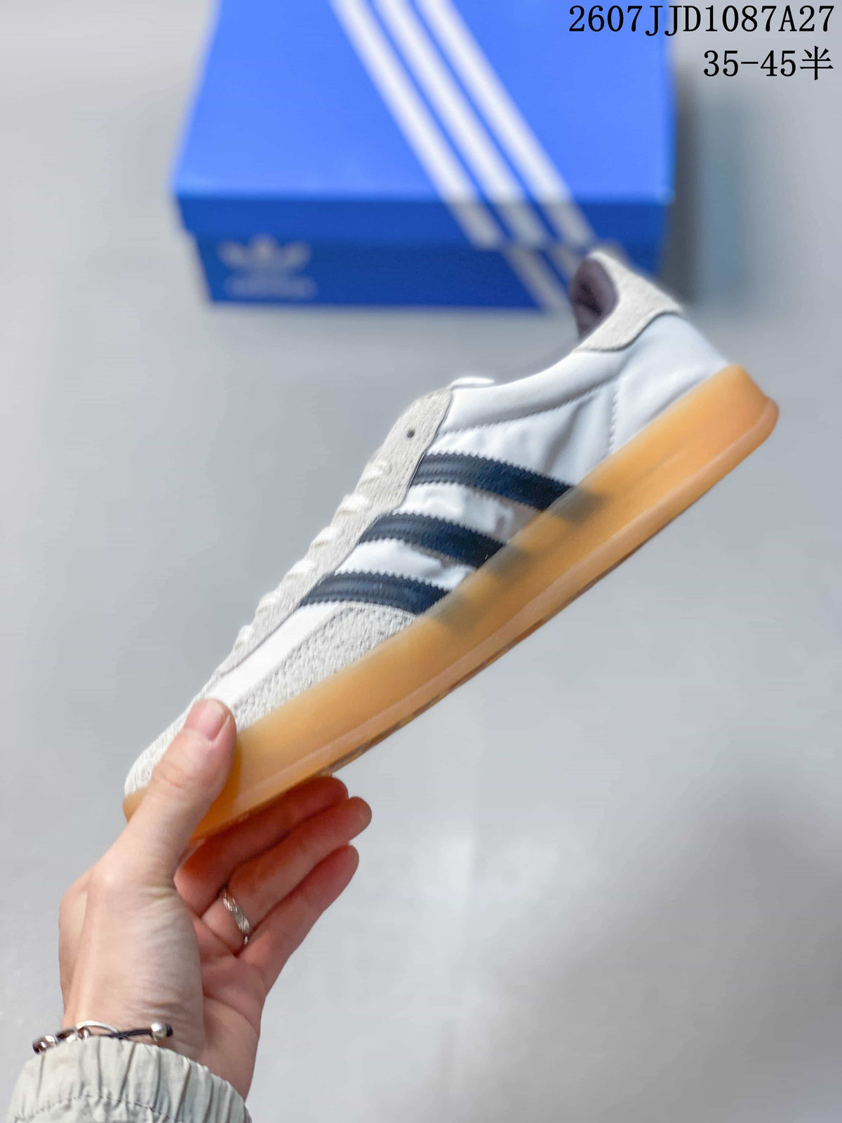 Side profile showing the low-top silhouette, white upper, navy stripes and gum-colored outsole.