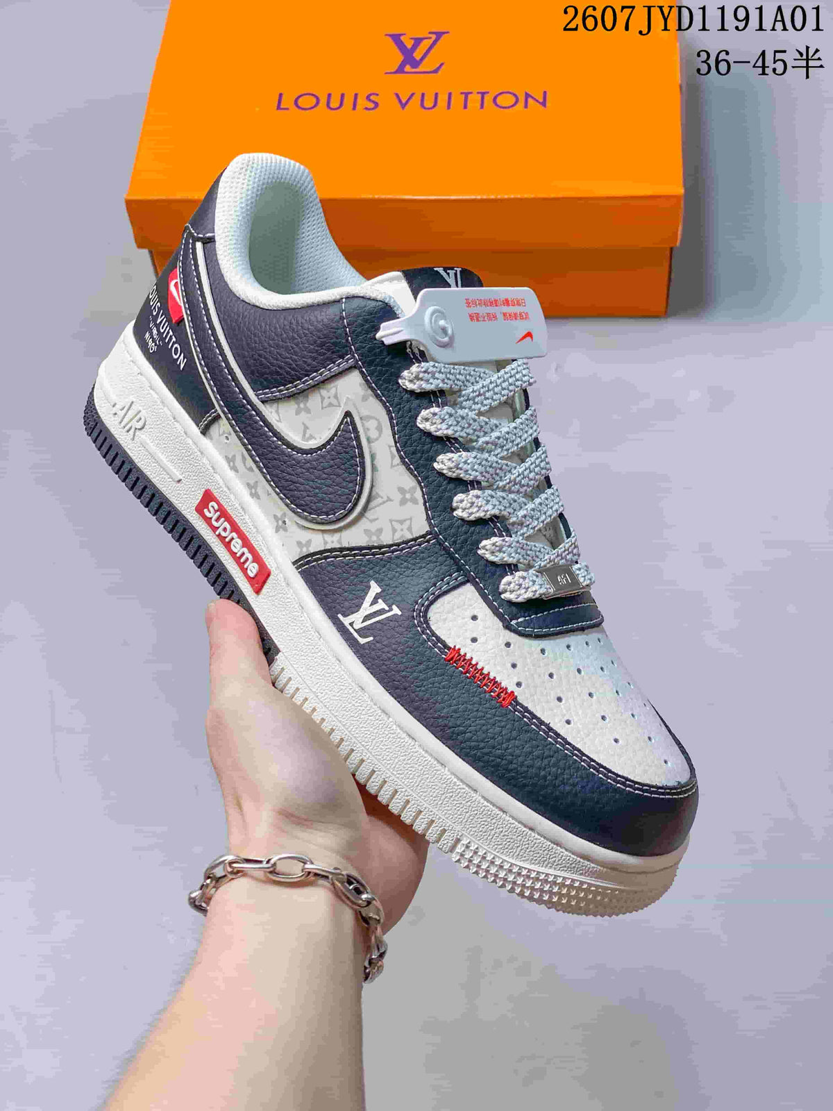 White low-top sneaker with dark navy panels, patterned side section, and red details