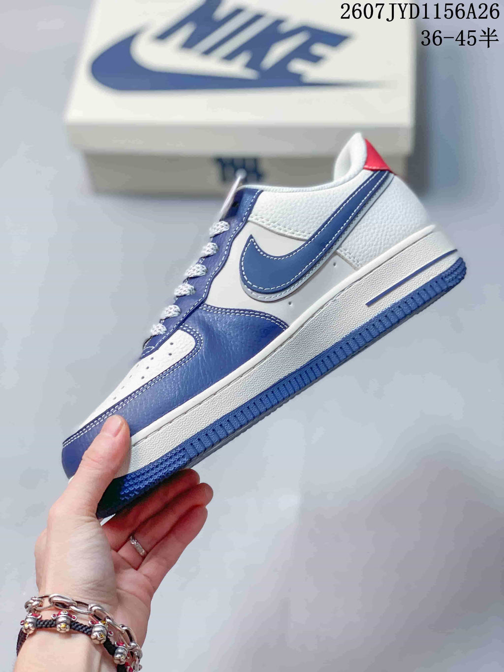 Side view showing the white and blue upper, layered Swoosh detail and blue outsole.