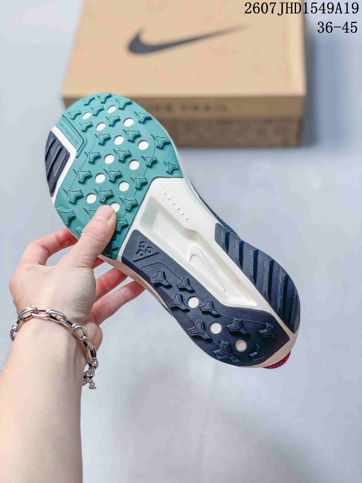 Bottom view showing the patterned teal and dark outsole of a Nike Zoom Fly 5 sneaker.