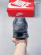 Rear view showing the heel and segmented cushioning of a dark Shox TL sneaker
