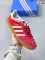 Angled side view of the red sneaker with white stripes and visible GA ZELLE side marking.