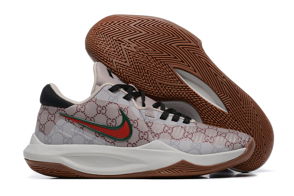Light neutral-colored basketball shoe with repeating monogram-style graphics and a brown outsole.