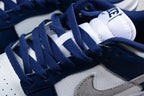 Close-up of navy laces, white tongue, navy overlays, and gray Swoosh on the sneaker.