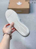 Close-up of the white sneaker outsole showing a textured geometric tread pattern; the image shows the code 2607JXD248A18 and size range 36–40.