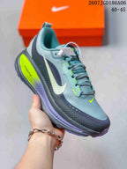 Angled side view of the gray Nike sneaker showing the Swoosh, dark overlays, neon yellow midsole insert, and textured outsole.