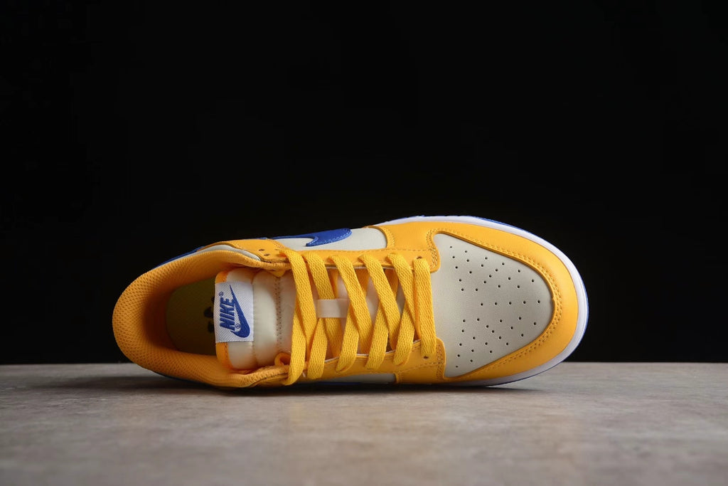 Top-down view of the sneaker showing yellow-gold laces, a perforated light-colored toe box, and padded collar.